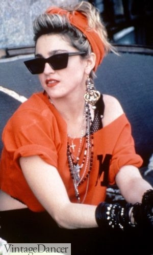Madonna wearing beaded necklaces and gold dangle earrings