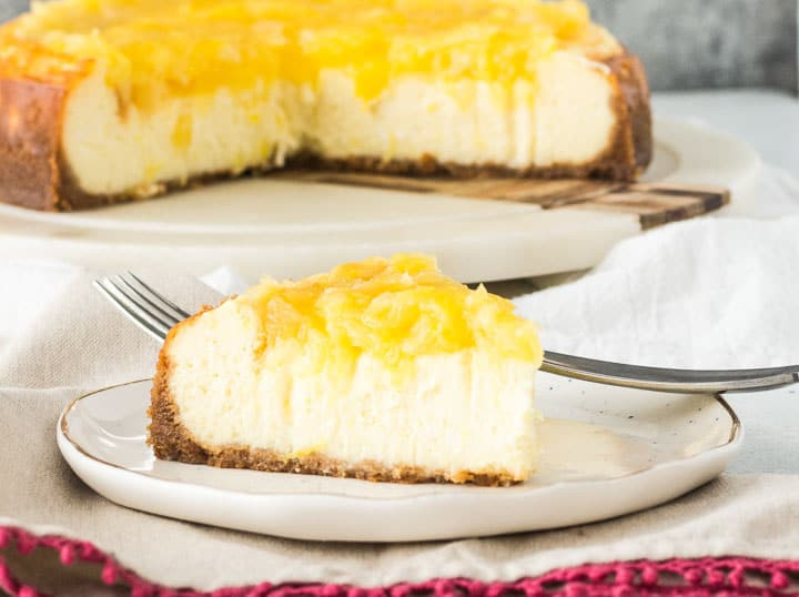 close up of a slice of pineapple cheesecake on a plate