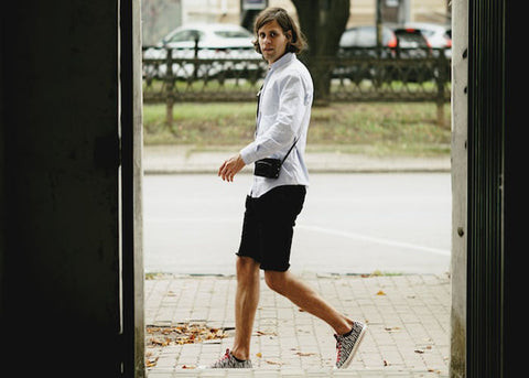 A pair of beige cargo shorts with multiple pockets, styled casually with a navy t-shirt