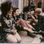 Punk style leather jacket, ripped jeans, and piercings, symbolizing rebellion and individuality