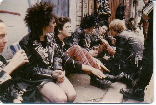 Punk style leather jacket, ripped jeans, and piercings, symbolizing rebellion and individuality