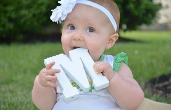 Adorable baby girl with wooden M