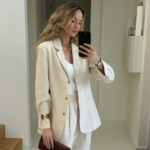 Woman wearing white best bodysuit with blazer and linen pants, showcasing tailored separates and a comfortable yet chic look