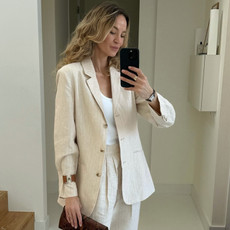 Woman wearing white best bodysuit with blazer and linen pants, showcasing tailored separates and a comfortable yet chic look