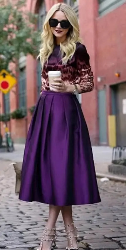 Woman wearing a white blouse with frills, paired with dark pants and heels, showcasing how frills add volume