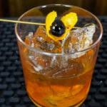 An Old Fashioned Bulleit Bourbon Cocktail with Orange Peel and Maraschino Cherry and 2 ounces bourbon