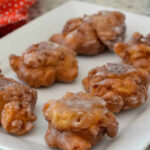 A close-up of a homemade apple fritter, showcasing the apple pieces and cinnamon, with a focus on healthier ingredient options.