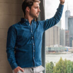 Short chubby guy wearing gray henley, navy chinos, and white sneakers