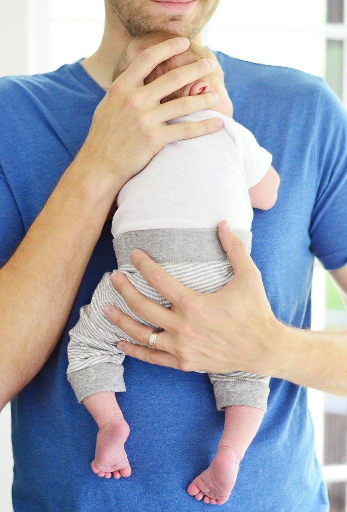 A father tenderly cradles his newborn baby boy against his chest, symbolizing the profound bond and love between them