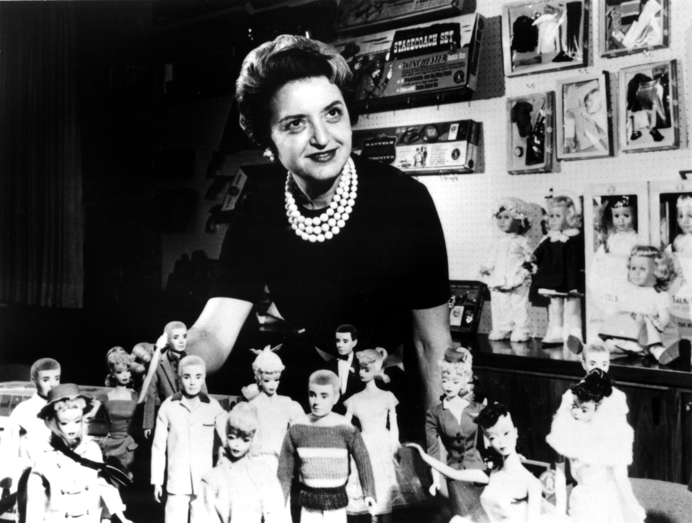 Ruth Handler poses with a group of Barbies