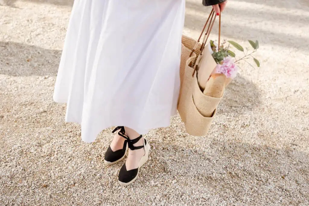 Man wearing a classic trench coat with straight-leg jeans and sneakers, showcasing a timeless and versatile style