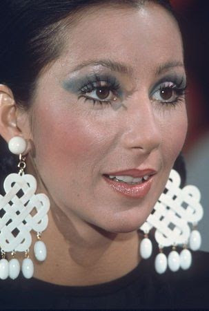 Cher, 1976, sporting glossy lips, a hallmark of 70s fashion makeup.
