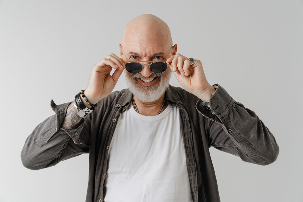 Bald man wearing a dark jacket and black sunglasses