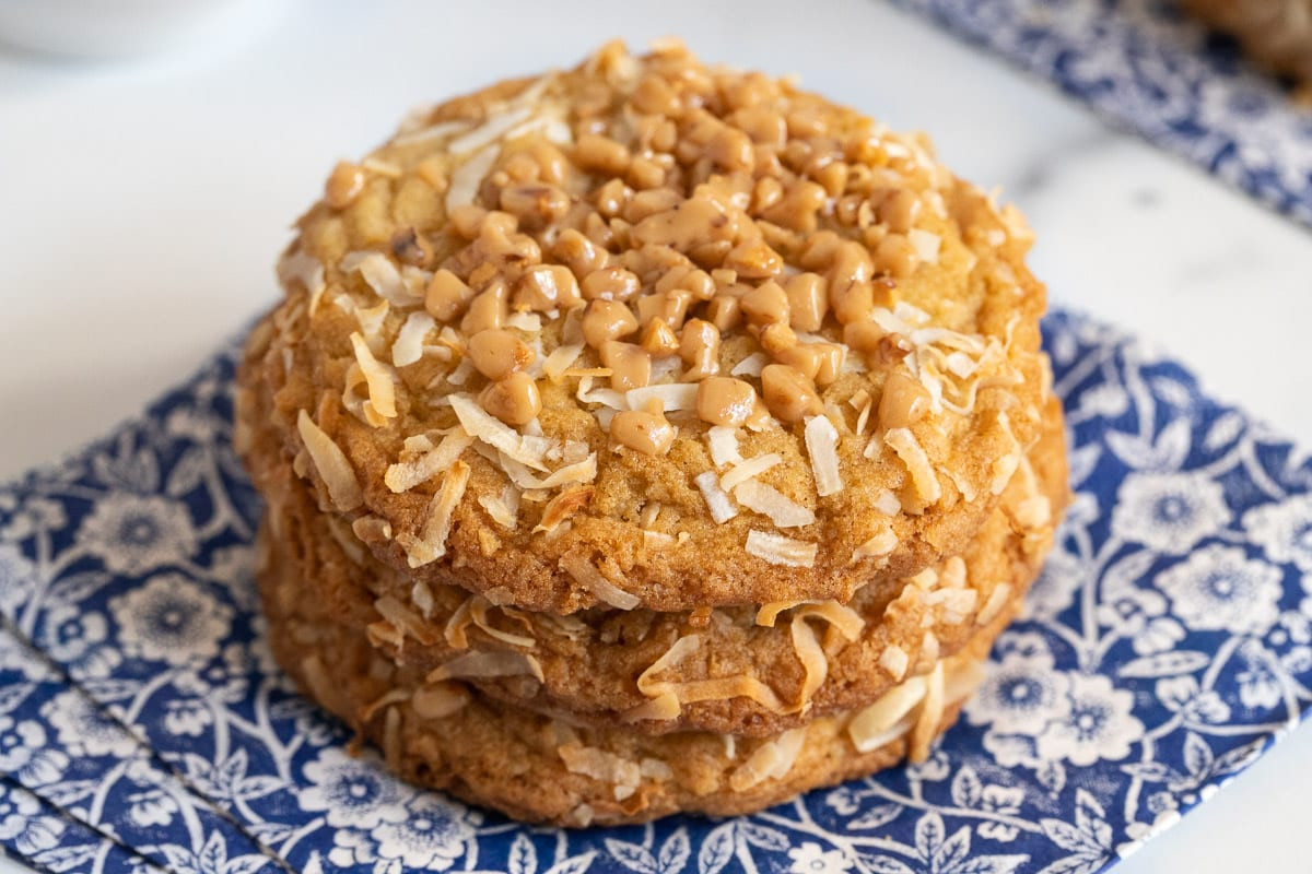 A close-up of crispy, chewy Carolina Coconut Cookies on blue and white patterned napkins.