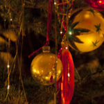 Old fashioned Christmas tree lit with warm candles, showcasing vintage glass ornaments
