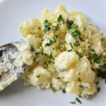 Old fashioned German potato salad with mayonnaise in a glass bowl