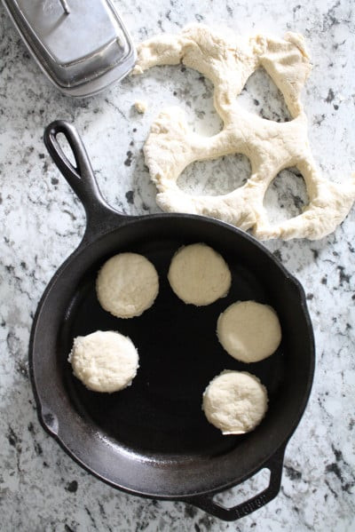 Homemade biscuits cut out and placed in cast iron skillet to be baked.