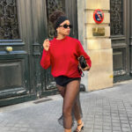 Man wearing a black sheer maxi skirt and red sweater, exuding bold winter style.