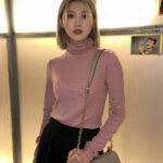 Man in a slim-fit turtleneck sweater with denim pants and pearl necklace, reflecting Korean winter fashion versatility