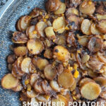 Close-up of smothered potatoes with onions and peppers in a pan