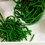Fresh green beans being prepared for cooking.
