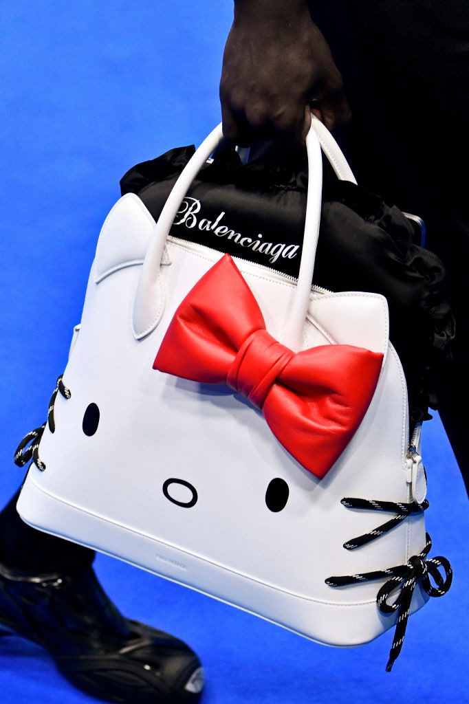A model showcasing the Hello Kitty Ville handbag from the Balenciaga collaboration, highlighting the high-fashion meets kawaii aesthetic.