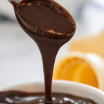 Pouring hot fudge sauce over ice cream