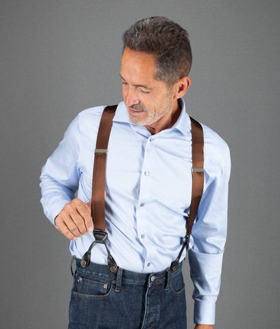 Man wearing brown suspenders over a white dress shirt