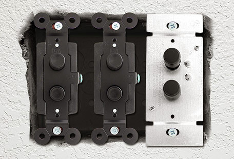 Close-up of a vintage-style push-button light switch with a brass finish