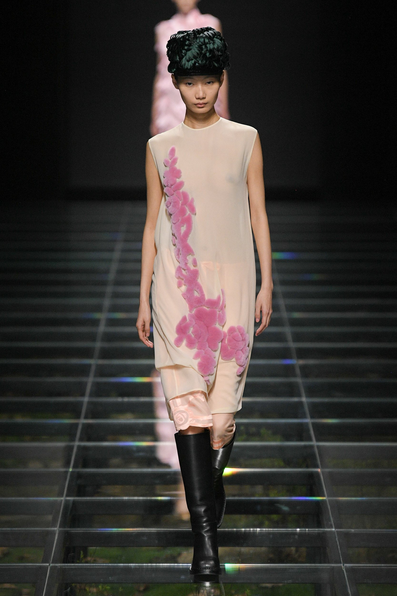 Model in Prada Fall 2024 collection wearing a black blazer and pleated skirt