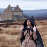 jane eyre wearing a hooded cloak