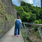 man wearing blue denim overalls with a white t-shirt and white sneakers