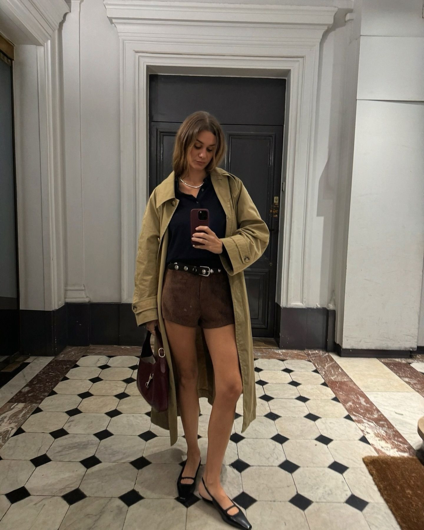 French influencer wearing a well-fitted gray suit and a white button-down shirt, embodying the sophisticated and effortless style associated with French fashion, showcasing how to pair classic tailoring with modern simplicity for a timeless and polished look.