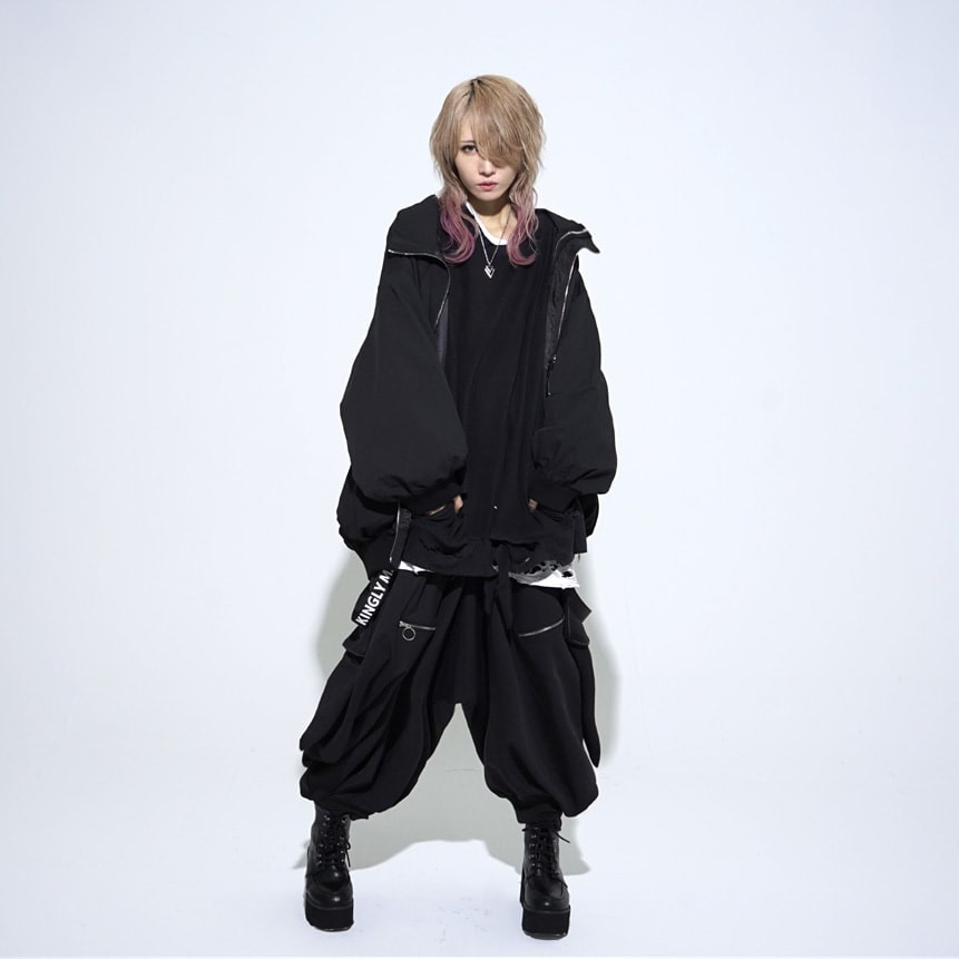 KINGLY MASK androgynous model wearing a big and baggy black outfit, highlighting the brand's Harajuku-born fusion of music and street fashion.