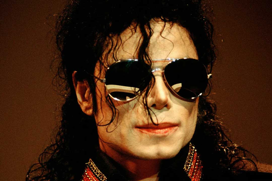 Michael Jackson with long dark hair wearing silver wire Aviator sunglasses frame