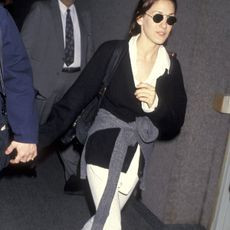 Man in a comfortable airport outfit with a grey sweater and jeans