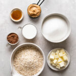 Ingredients for no-bake oatmeal cookies, including oats, cocoa powder, peanut butter, and butter.