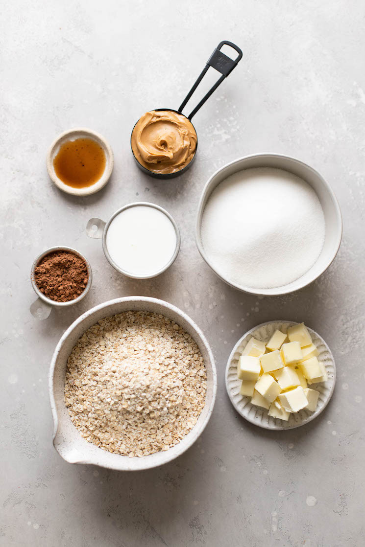 Ingredients for no-bake oatmeal cookies, including oats, cocoa powder, peanut butter, and butter.
