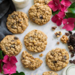 Oatmeal Raisin Cookies scattered over a marble surface, decorated with flowers.