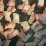 Chopped bacon sizzling in a skillet, releasing its savory aroma.