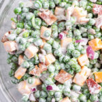 overhead close up pea salad in glass bowl