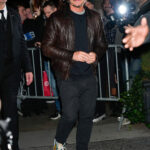 Pedro Pascal in leather jacket and sneakers giving strong 90s dad vibes, pairing a beat-up leather jacket with well-loved New Balance sneakers for a cool and effortless look.