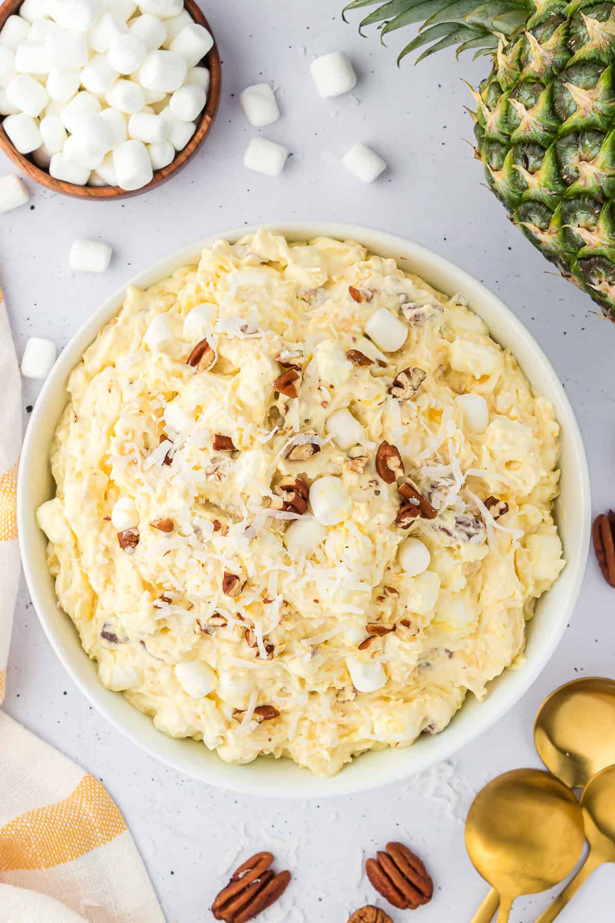 Bowl of pineapple fluff surrounded by ingredients