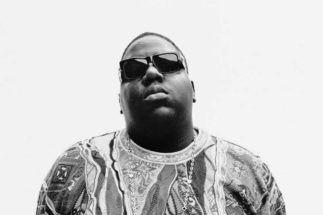 Portrait of rapper Biggie Smalls wearing black Versace sunglasses
