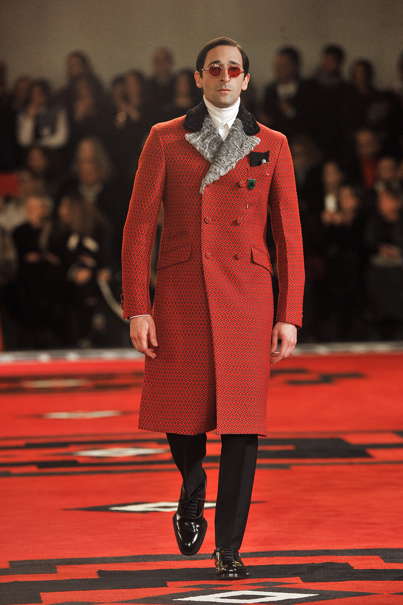 Adrien Brody, famed for roles in "The Pianist" and "King Kong," presents Prada's cutting-edge menswear on the Milan runway at the Autumn/Winter 2012 fashion show during Milan Menswear Fashion Week.