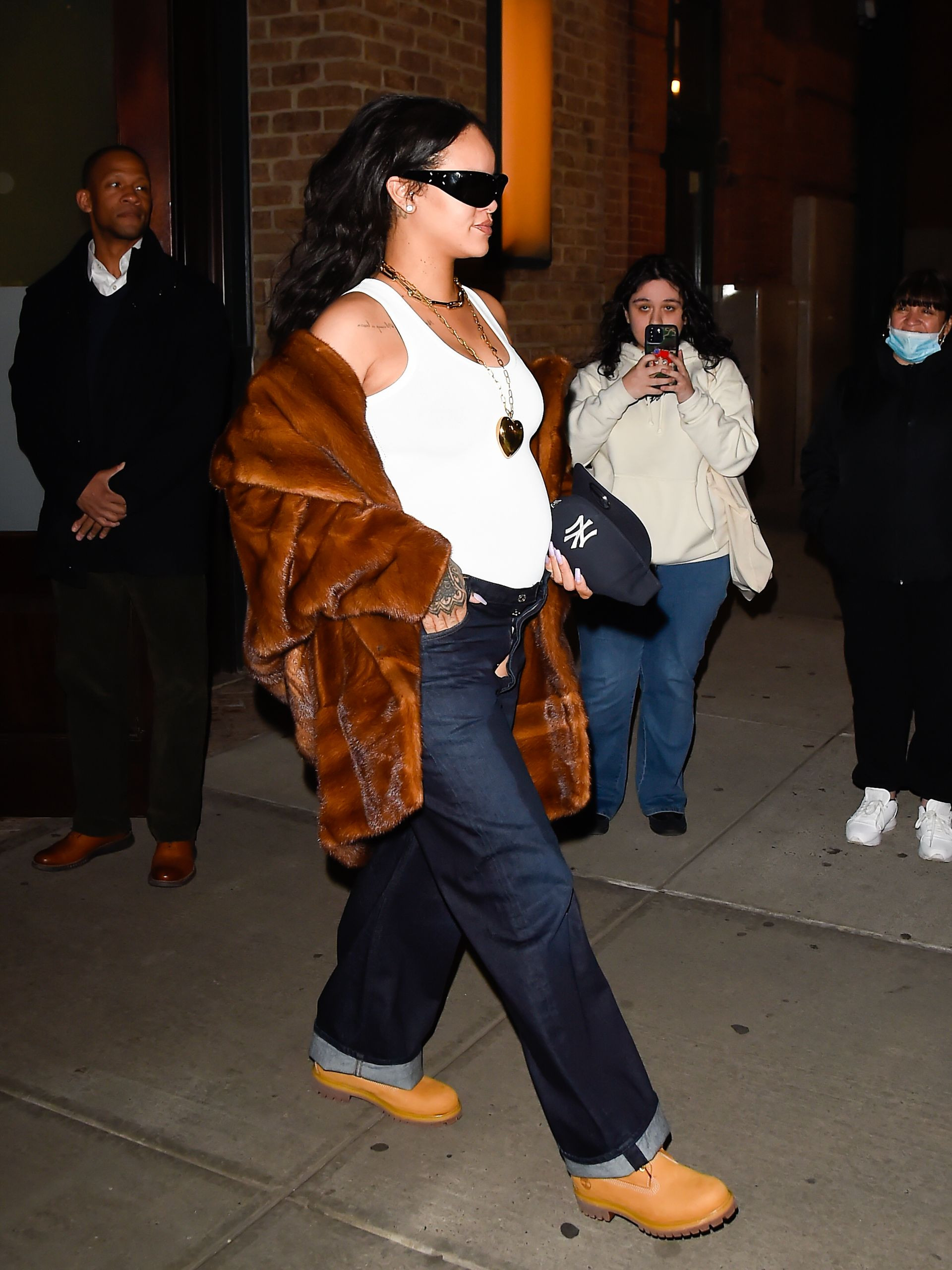 Rihanna's iconic pregnancy style featuring a crop top and low-rise jeans, showcasing her confidence and bold fashion choices.