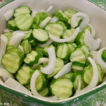 Sliced cucumbers and onions in a bowl