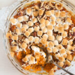 Sweet potato casserole with marshmallow topping, baked in a dish, ready to be served during Thanksgiving dinner, showcasing a blend of traditional and comforting food.