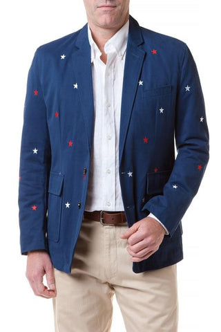 Men in creamy-colored trousers, tan shoes, and navy blazers with women in tan trousers, as well as tucked-in white shirts and tweed blazers, creating an equestrian vibe
