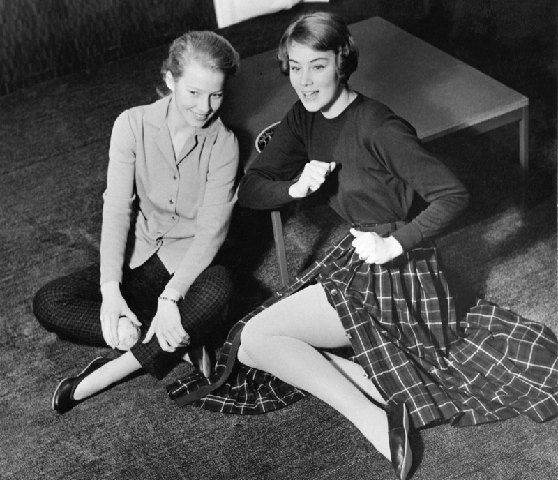 Teenagers in capri pants and circle skirt, representing popular casual 1950s fashion for women.